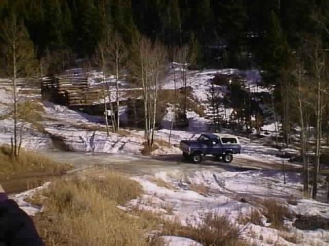 1996 Ford Bronco - Blue 1996 Ford Bronco navigates a snowy, wooded area.