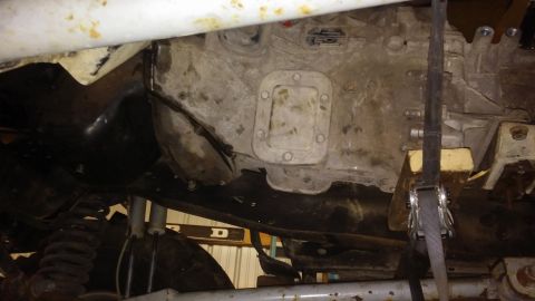 1995 Ford Bronco - The underside of a vehicle is shown, with the transmission and suspension parts visible.