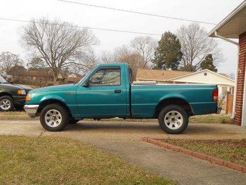 1997 Ford Ranger - A teal 1997 Ford Ranger pickup truck is parked on a concrete driveway next to a house.