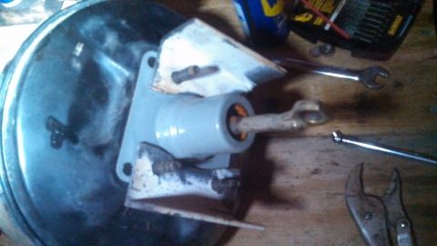 1979 Ford Bronco - A brake booster and master cylinder assembly is shown with various tools on a wooden surface.