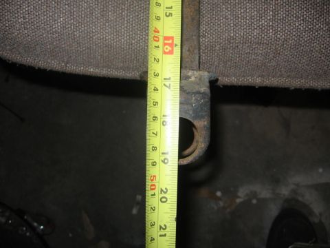 1988 Ford Bronco - A tape measure is used to measure a metal bracket, likely a vehicle part.