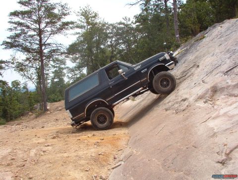1988 Ford Bronco - Black Ford Bronco navigates a challenging rocky terrain, its off-road capabilities.