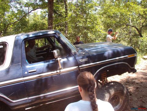 1988 Ford Bronco - This lifted Ford Bronco, likely from the late 1970s, is shown off-road with people around.