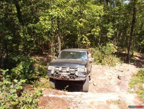 1988 Ford Bronco - This 1988 Ford Bronco navigates a rocky, wooded trail with auxiliary lighting and a winch mounted on the front bumper.
