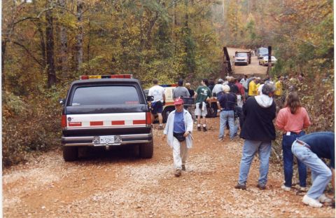 1988 Ford Bronco - A black 1988 Ford Bronco with emergency lights on the roof and a license plate reading "MG 52863" is parked on a dirt road in a wooded area…