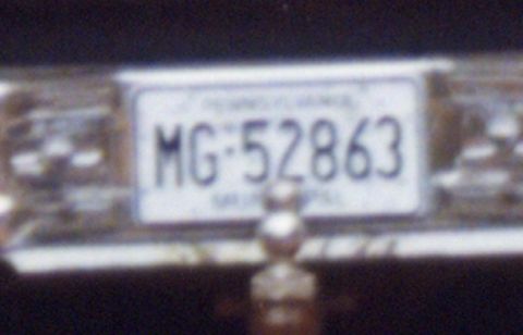 1988 Ford Bronco - A close-up shot of a white license plate with black text that reads "MG-52863". The plate is mounted on a vehicle.