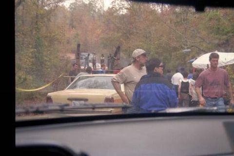 1988 Ford Bronco - A yellow Ford Crown Victoria police car is parked behind a yellow caution tape in a wooded area. Several people are gathered around the car…