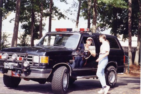 1988 Ford Bronco - A black Ford Bronco SUV with a light bar and winch is parked outdoors with two people standing nearby. The vehicle has off-road tires and a…
