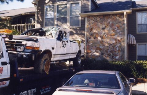 1988 Ford Bronco - A severely damaged white Ford pickup truck is loaded onto a tow truck. The truck's windshield is shattered, and the front passenger-side wh…