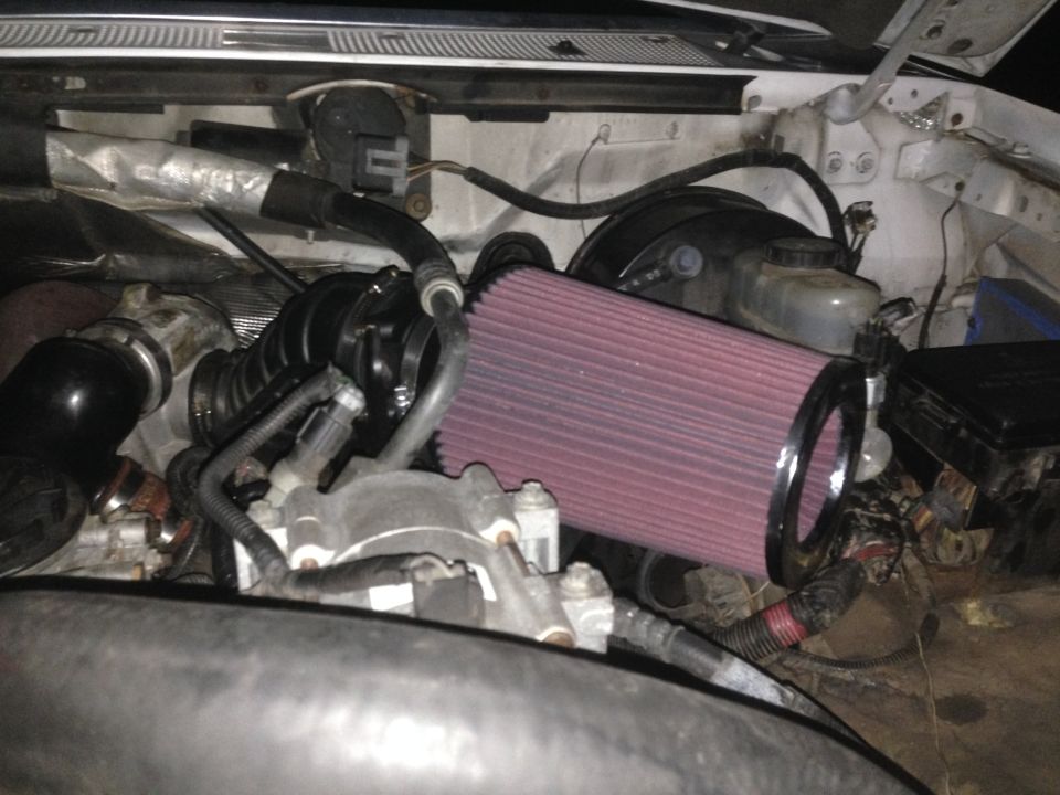 1997 Ford F-250 engine bay with red cone air filter and intake system.