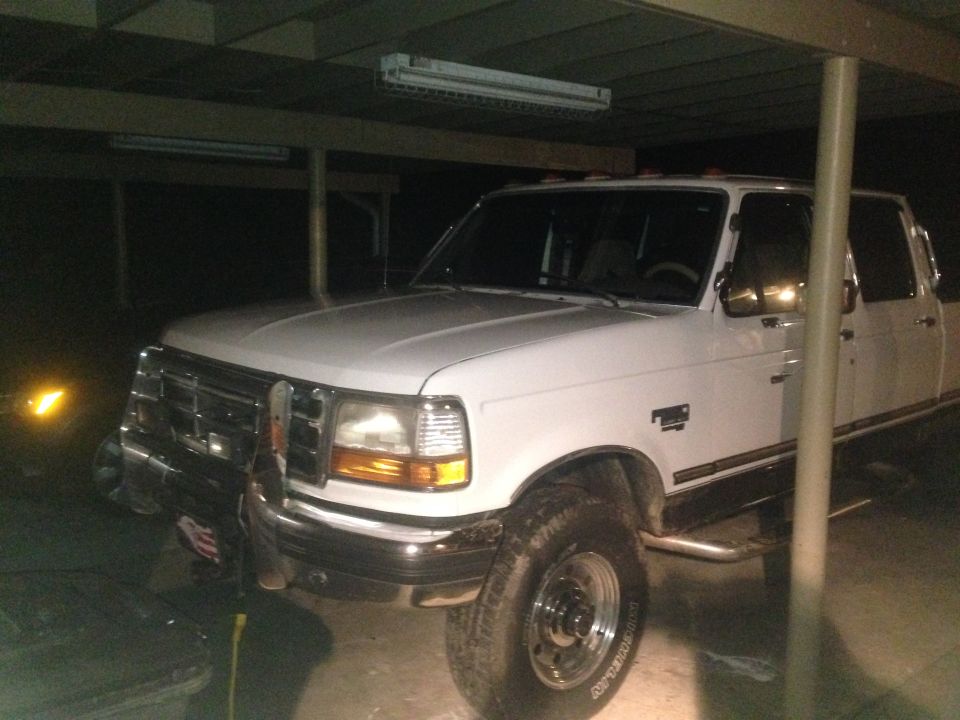 White 1997 Ford F-250 Super Duty pickup truck parked under a cover.