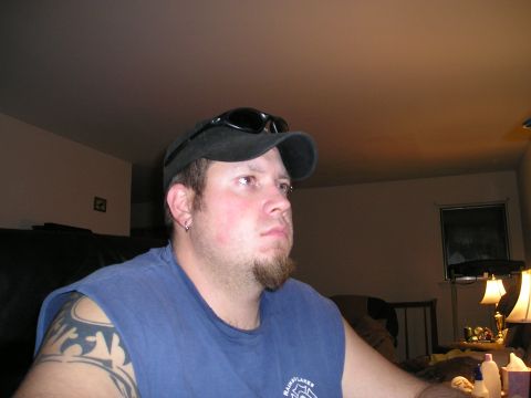 1994 Ford F-150 - Man with a goatee and tattoos wearing a baseball cap and sunglasses indoors.