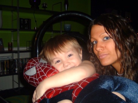 1997 Ford Taurus - A woman and child pose for a photo indoors, with a Spider-Man toy and a steering wheel visible.