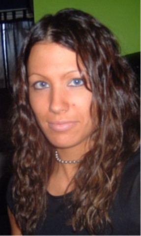 1997 Ford Taurus - A woman with long, curly brown hair and striking blue eyes is pictured, adorned with a simple beaded necklace.