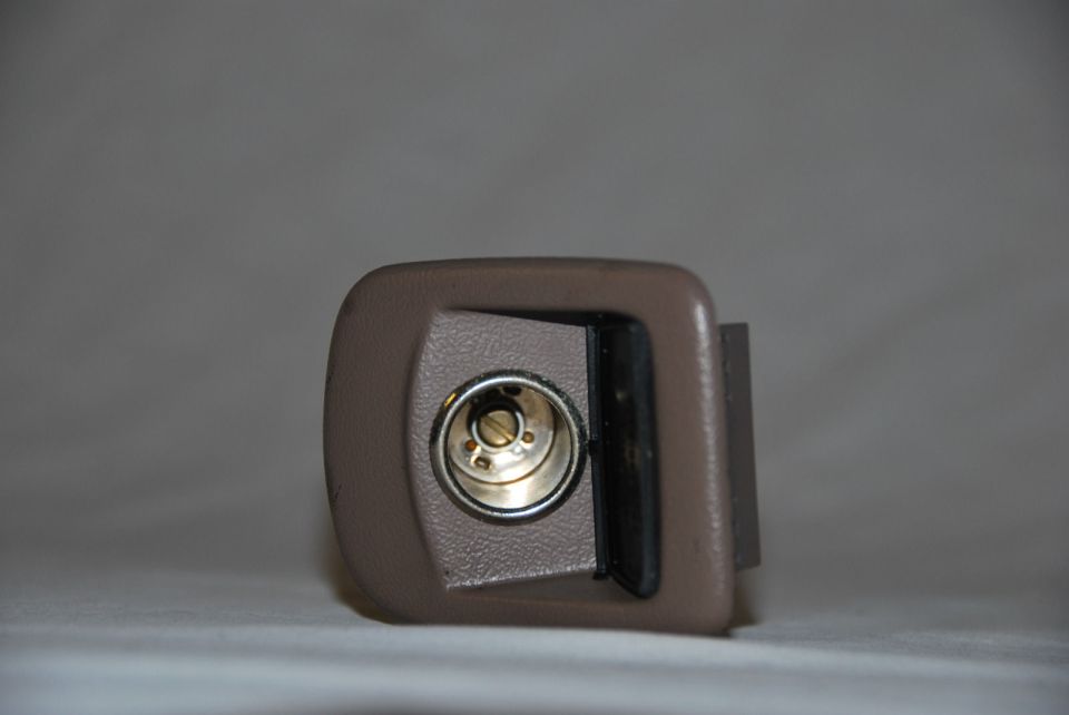 Dark gray dashboard speaker with a metallic cone, viewed from the front
