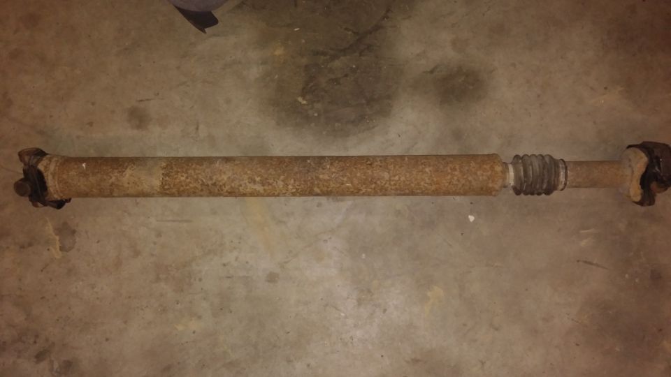 Rusty driveshaft with U-joints and a rubber boot