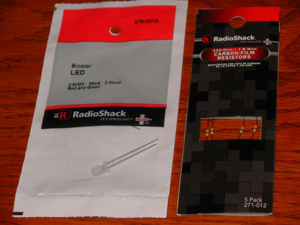 RadioShack bicolor LED package and 5-pack of 330-ohm resistors on a wood table