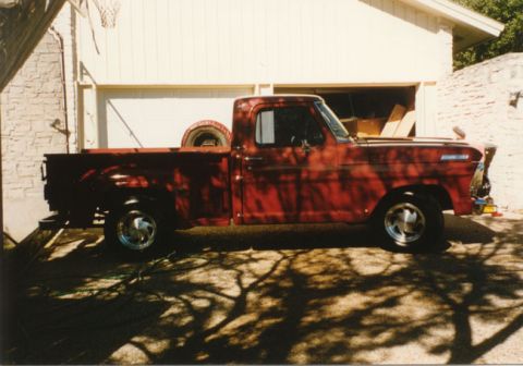 1967 Ford F-100 - This red 1967 Ford F-100 pickup truck is parked in front of a garage.