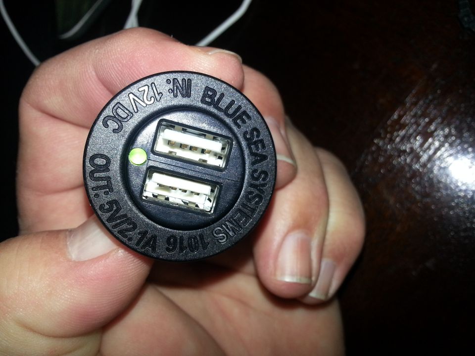 Photo of a hand holding a Blue Sea dual USB charger socket