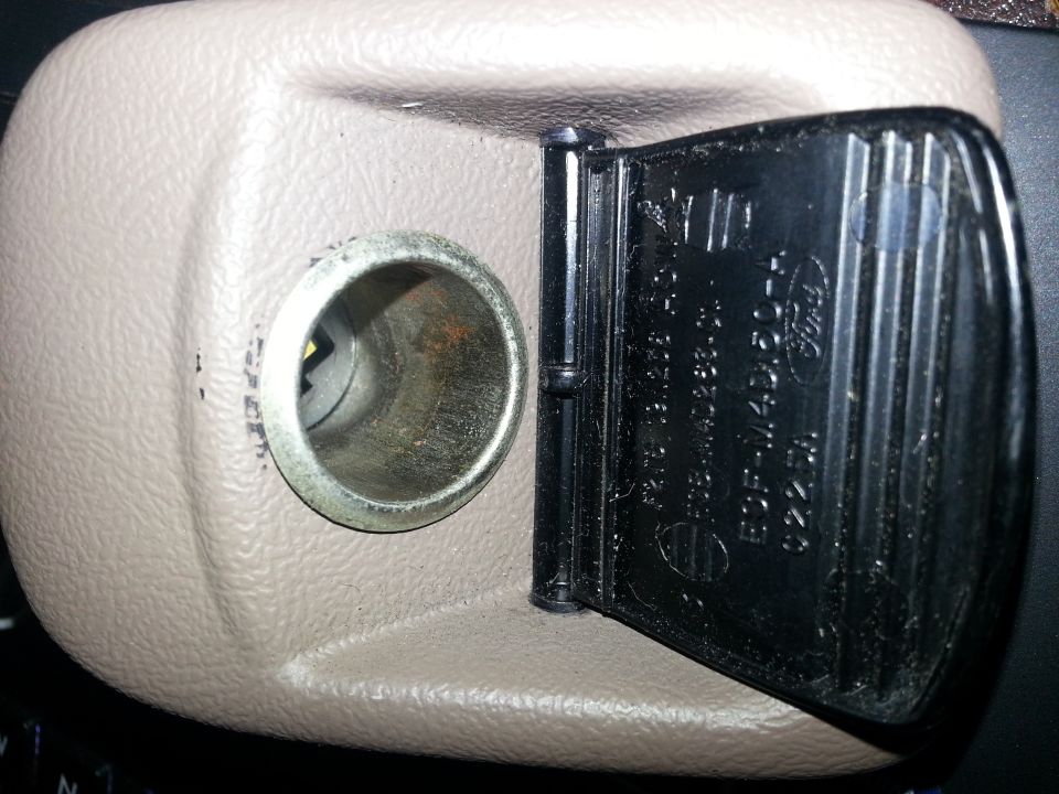 Beige dash power-point housing with hinged cover showing Ford part-number molding