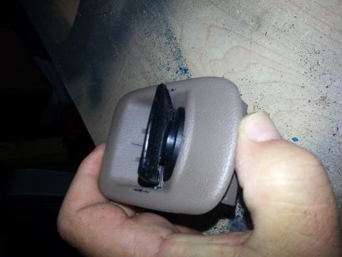 1994 Ford Bronco - Photo of a beige interior power-point housing with a black gasketed cap held in a hand.
