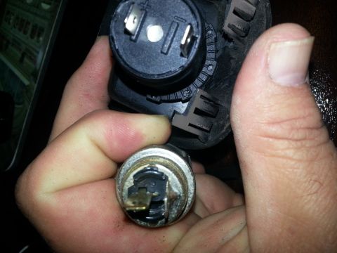 1994 Ford Bronco - Photo of a black power-socket terminal end and a metal cigarette-lighter element in hand.