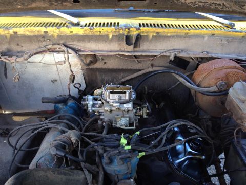 1979 Ford Bronco - The engine bay of a classic Ford Bronco shows a newly installed carburetor and various engine components, including spark plug wires and a…