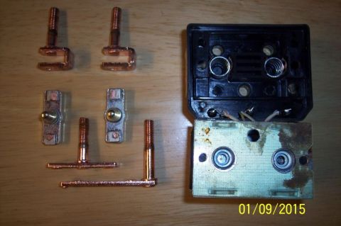 1973 Ford F-250 - Several copper electrical components, including terminal connectors and what appears to be parts of a circuit breaker or relay, are laid ou…