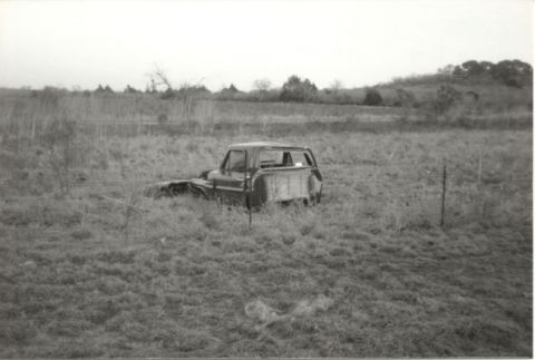 1967 Ford F-100 - This 1967 Ford F-100 pickup truck appears to have been abandoned in a grassy field, with its front end partially obscured by the terrain.