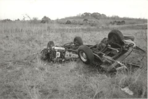 1967 Ford F-100 - A damaged truck chassis lies on its side in a field, indicating a past accident.