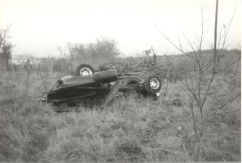 1967 Ford F-100 - A 1967 Ford F-100 pickup truck lies on its side in a field after an apparent accident.