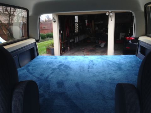 1989 Ford Bronco - View from inside a vehicle's rear cargo area, looking out into a garage.