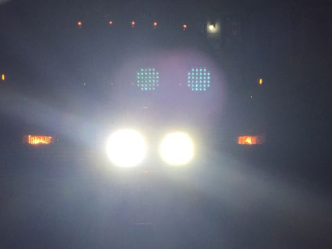 2005 Ford Excursion - The front of a vehicle is illuminated at night by its headlights, with additional lights visible above.
