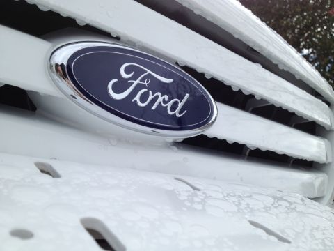2004 Ford Crown Victoria - Close-up of a white Ford grille with a blue oval Ford emblem and water droplets.