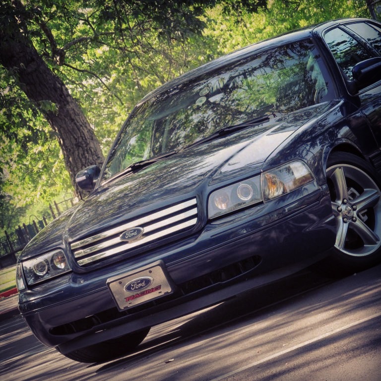Dark blue Ford Crown Victoria front three-quarter view with Ford grille and five-spoke wheels