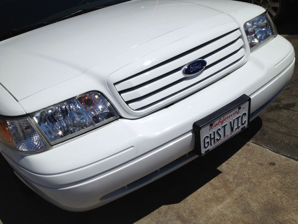 White Ford sedan front end, grille and California GHST VIC plate