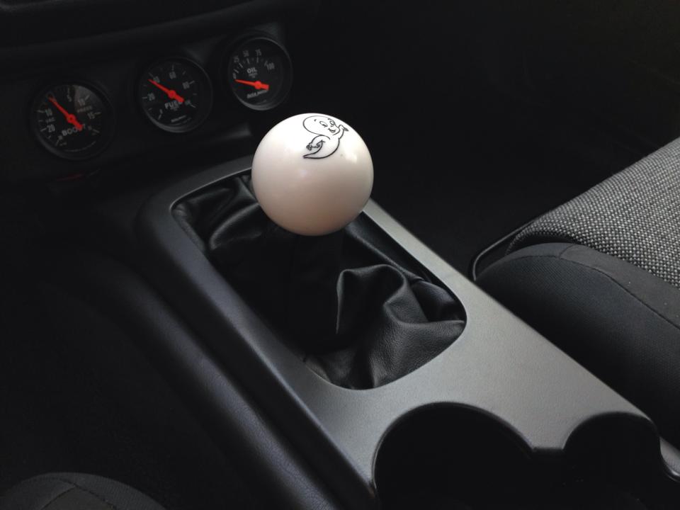 White shift knob with ghost graphic on center console, next to gauges