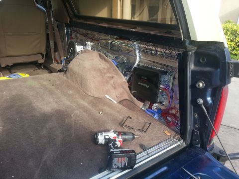 1994 Ford Bronco - The rear interior of a vehicle is being modified with soundproofing and audio equipment, with tools nearby.