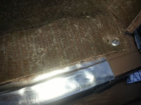 1994 Ford Bronco - Close-up of the interior carpet and trim, showing some wear and tear.