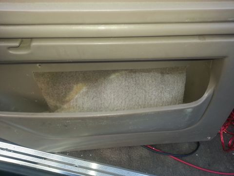 1994 Ford Bronco - Close-up of a vehicle's interior door panel storage pocket, showing wiring underneath.