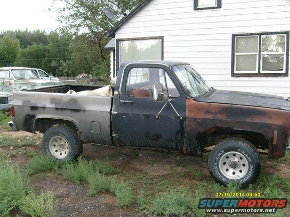 Side view of a 1979 GMC Sierra 1500 pickup truck with black and rust colored body panels