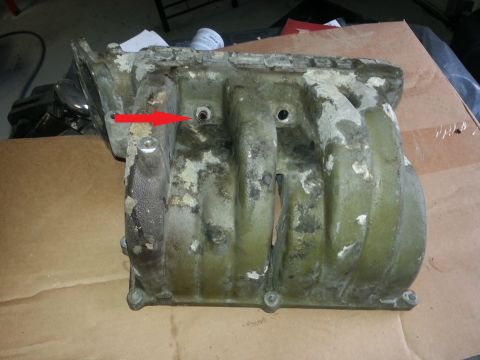 1994 Ford Bronco - An intake manifold is shown, with a red arrow indicating a bolt hole.