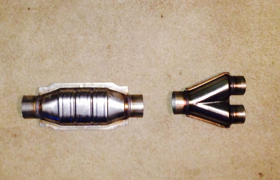 Catalytic converter and Y-pipe exhaust components on a tan surface