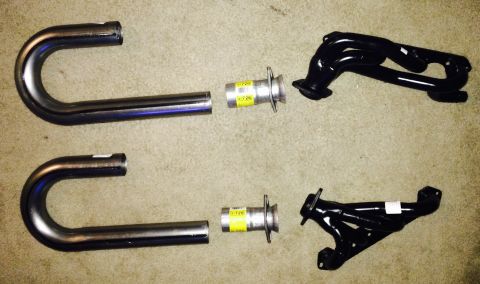 1996 Ford Bronco - Exhaust system components laid out on a carpeted surface, including pipes and manifolds.