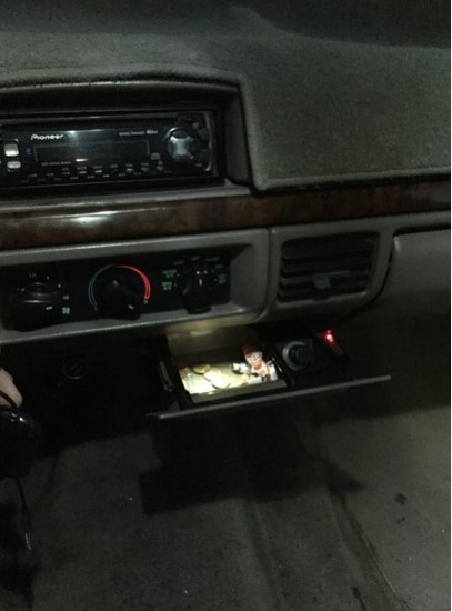 1996 Ford Bronco - The interior dashboard features a Pioneer stereo and an open storage compartment revealing a personal photograph.