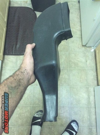 1996 Ford Bronco - Black plastic air intake duct held by a person's hand.