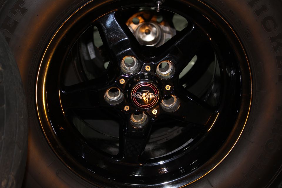 Close-up of black drag wheel center cap with red and gold logo