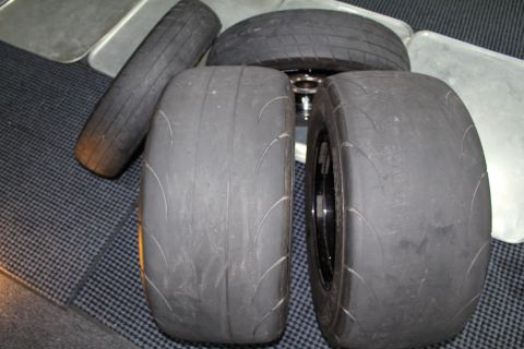 2003 Ford Crown Victoria - Worn tires, including two racing slicks, are displayed on a checkered surface.