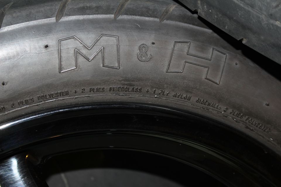 Tire sidewall embossed M&H with ply construction text