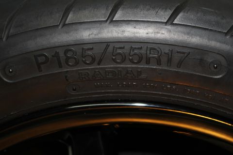 2003 Ford Crown Victoria - close-up of a tire sidewall embossed P185/55R17 RADIAL mounted on a glossy black wheel.
